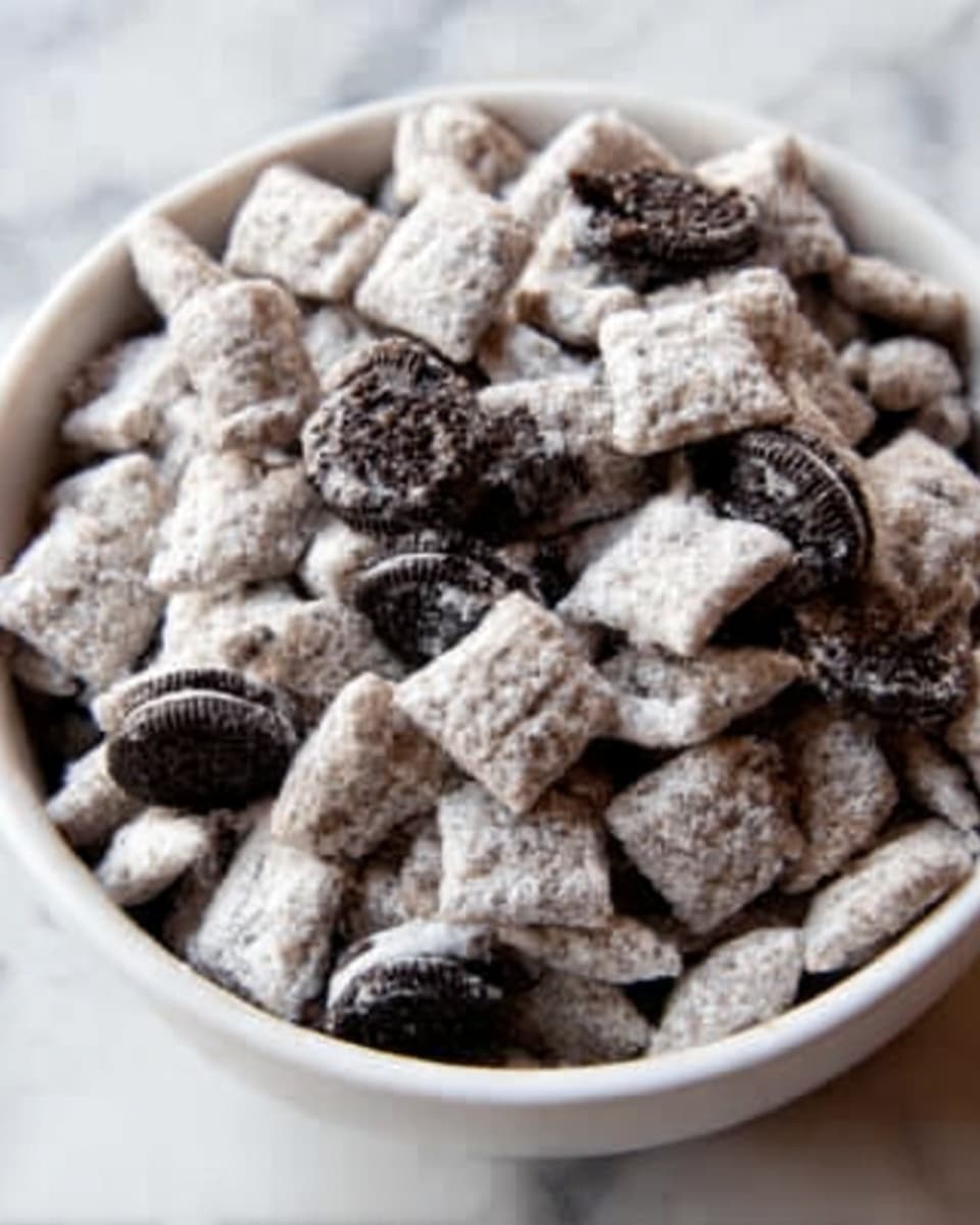 A white bowl filled with a close-up view of a snack mix consisting of light-colored square cereal pieces coated in a powdery white layer and mixed with small round chocolate sandwich cookie chunks, showing a rough, crumbly texture. The cereal squares have a rough texture due to the coating, and the dark cookies with white cream centers create a strong contrast. The bowl sits on a white marbled surface. Photo taken with an iphone --ar 4:5 --v 7