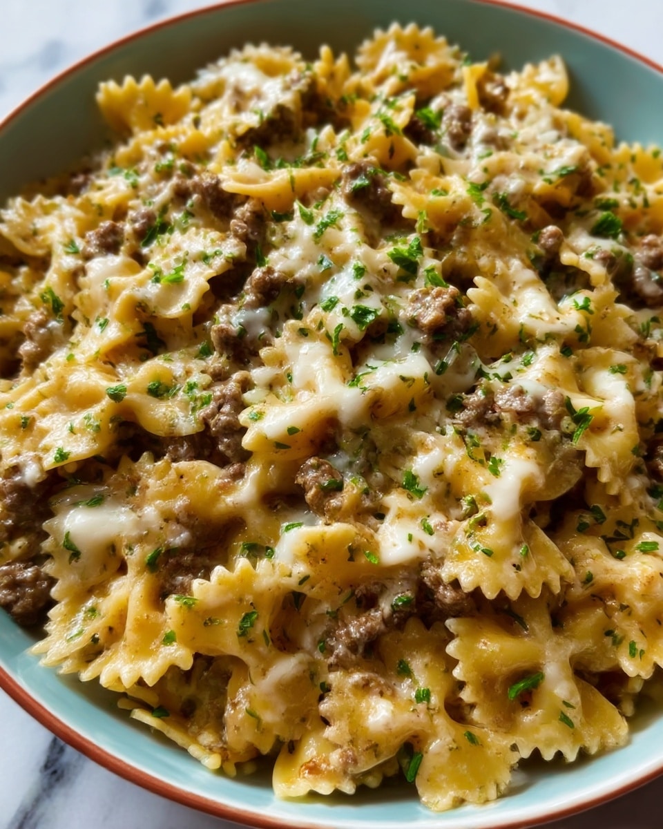 The image shows a close-up of a pasta dish with farfalle noodles mixed with browned ground meat and creamy sauce, topped with finely chopped green herbs. The noodles are a light golden color, the meat is brown and crumbly, and the sauce looks smooth and slightly thick, covering the pasta evenly. Small pieces of the herbs are scattered over the top, adding a fresh touch. The dish is placed on a white plate, against a white marbled background. photo taken with an iphone --ar 4:5 --v 7