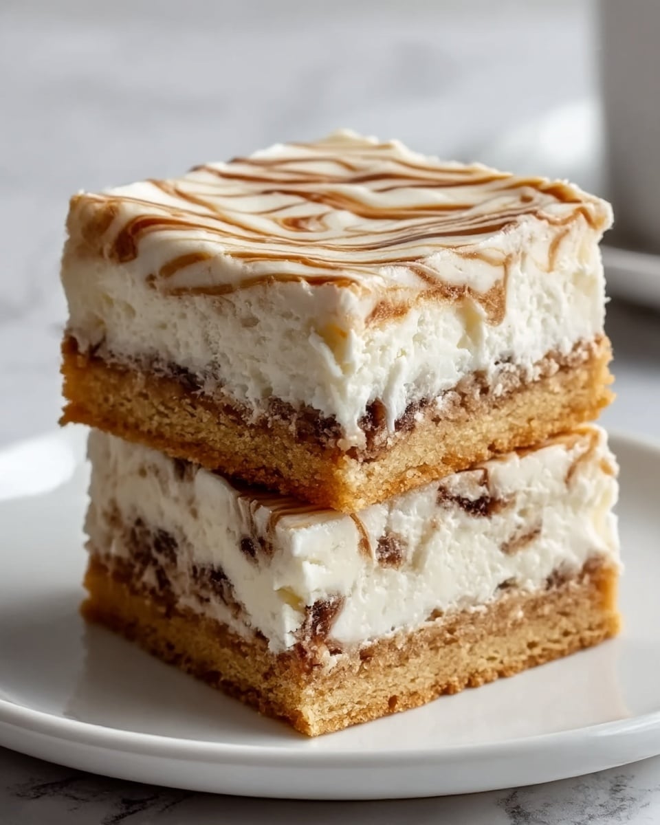 The image shows two thick layers of a dessert stacked on a small white plate with a white marbled background. The bottom layer is golden brown and looks crisp with a slightly crumbly texture. The middle layer is creamy white frosting that is smooth and thick. The top layer is a mix of golden brown and white swirls, with the brown part looking like baked dough with some texture, while the white part is soft frosting spread on top. The dessert has clean edges and looks soft and rich. Photo taken with an iphone --ar 4:5 --v 7
